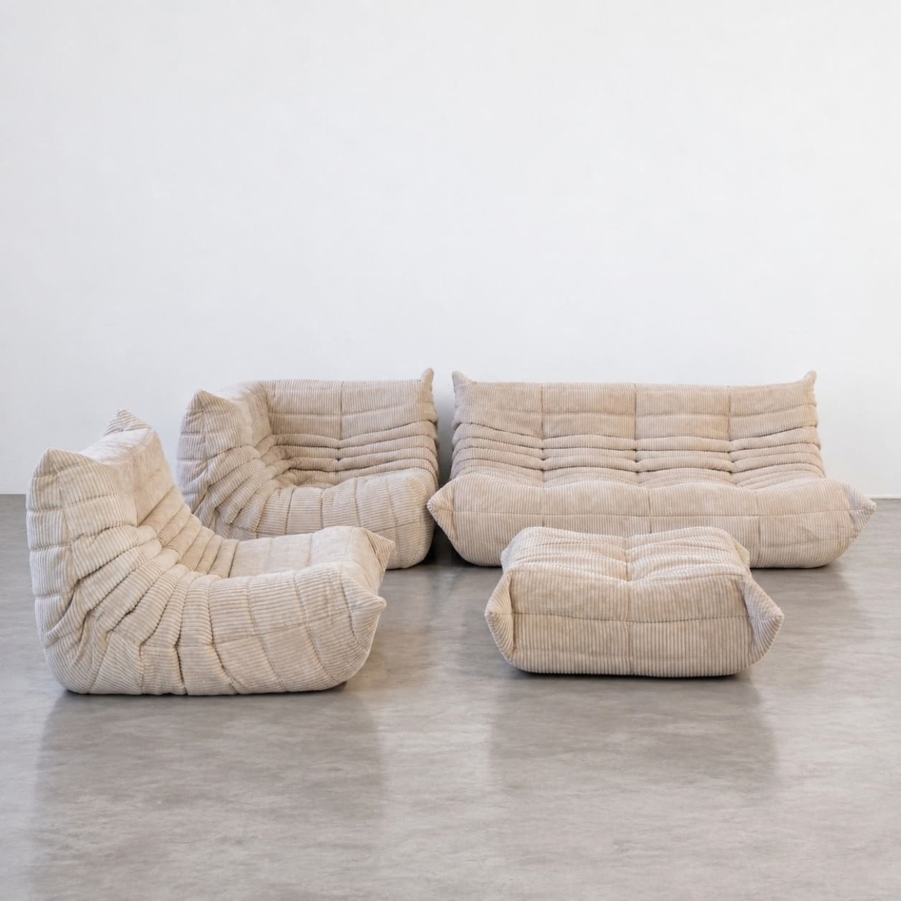 Zestawienie modułów Togo w beżowym sztruksie, sofa 3-osobowa, sofa narożna, fotel i puf