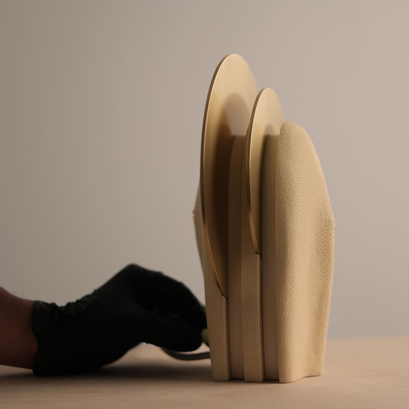 Side view of Mother of the Light showing overlapping brass discs and shagreen-covered body