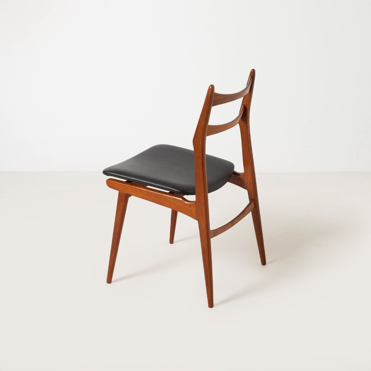 Habeo Boomerang teak chair, rear side view.