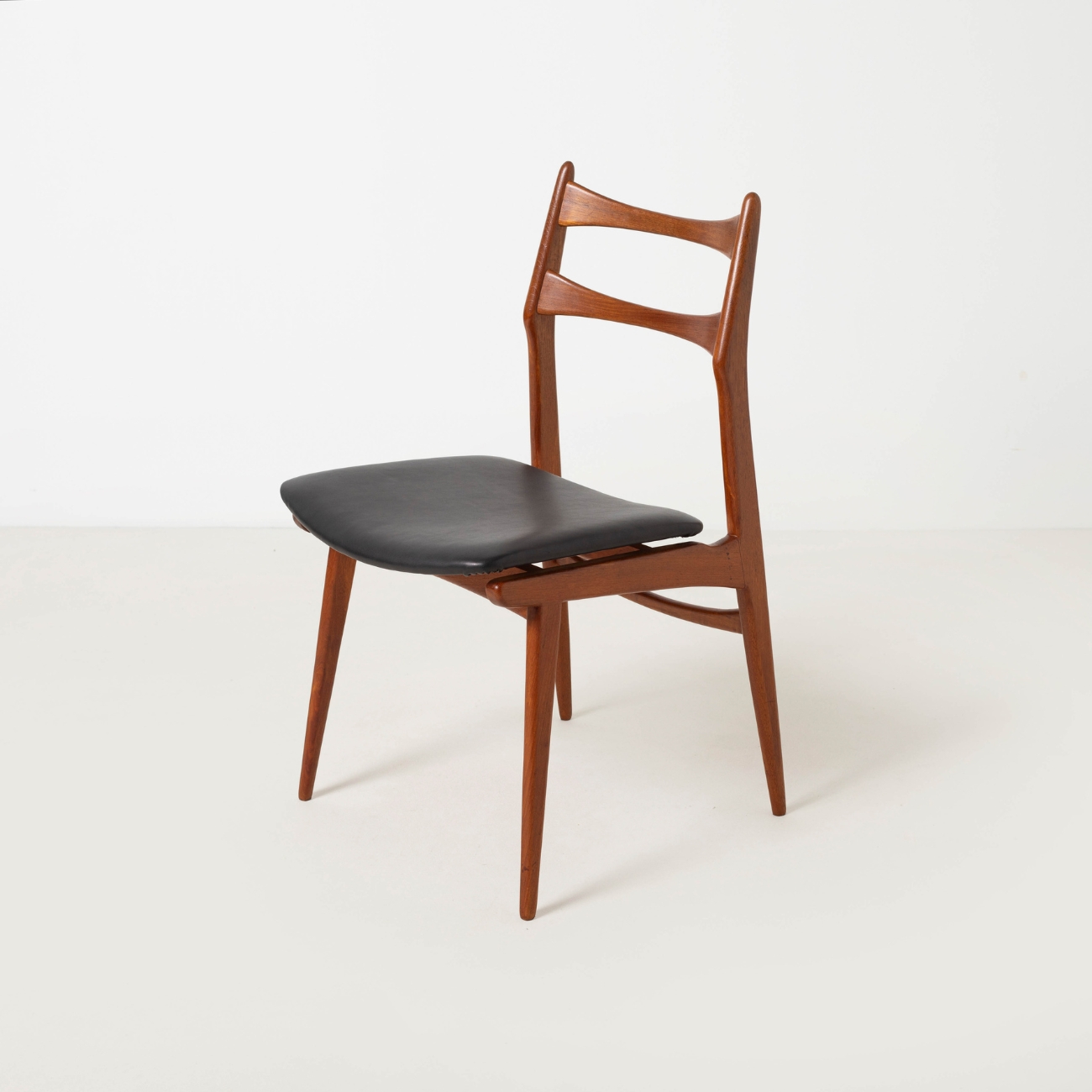 Habeo Boomerang teak chair with new dark brown aniline leather upholstery.