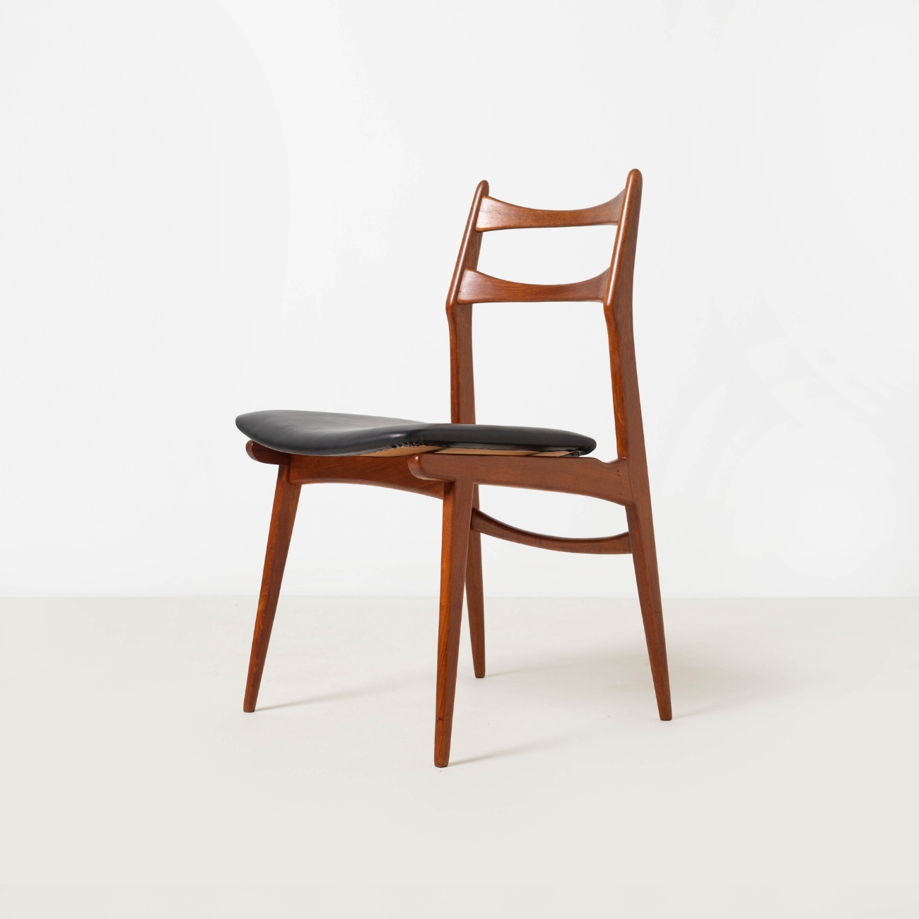 Habeo Boomerang teak chair, left profile view.