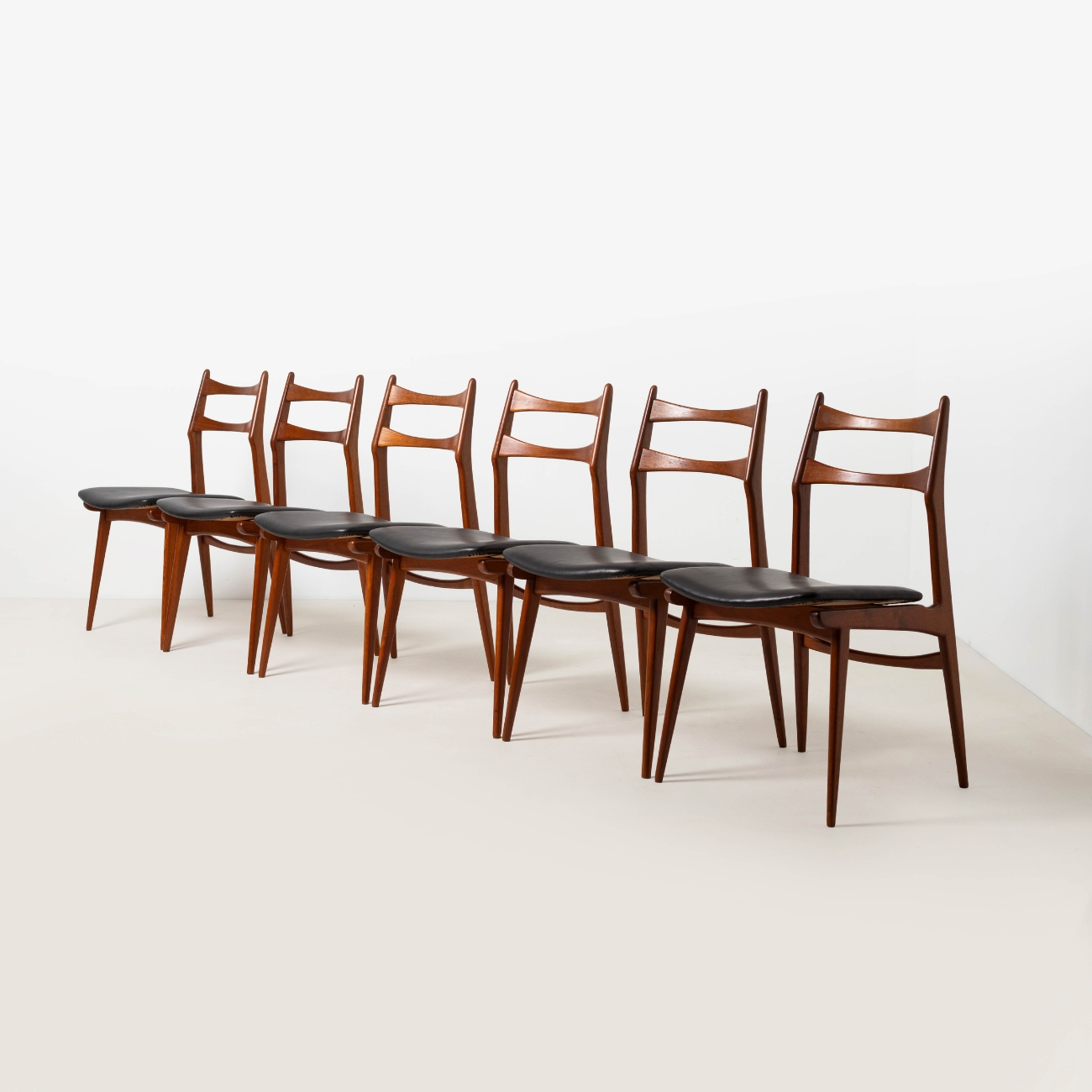 Set of six restored Habeo Boomerang teak dining chairs with aniline leather seats.