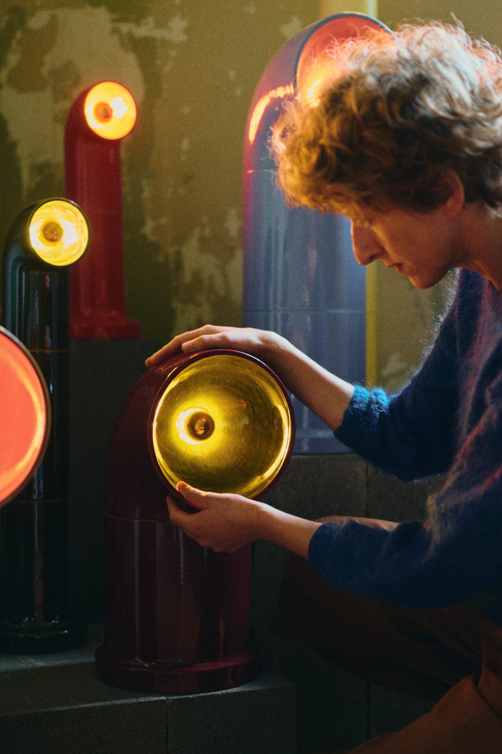Designer Magda Jurek interacting with an OP ceramic light object during the exhibition