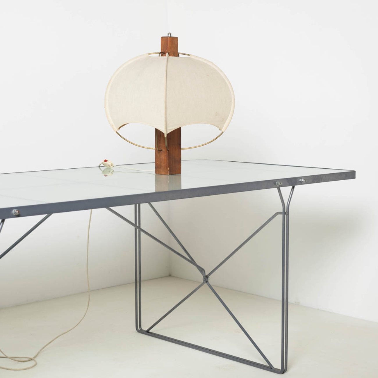 Postmodern wooden and fabric table lamp displayed on a glass table.