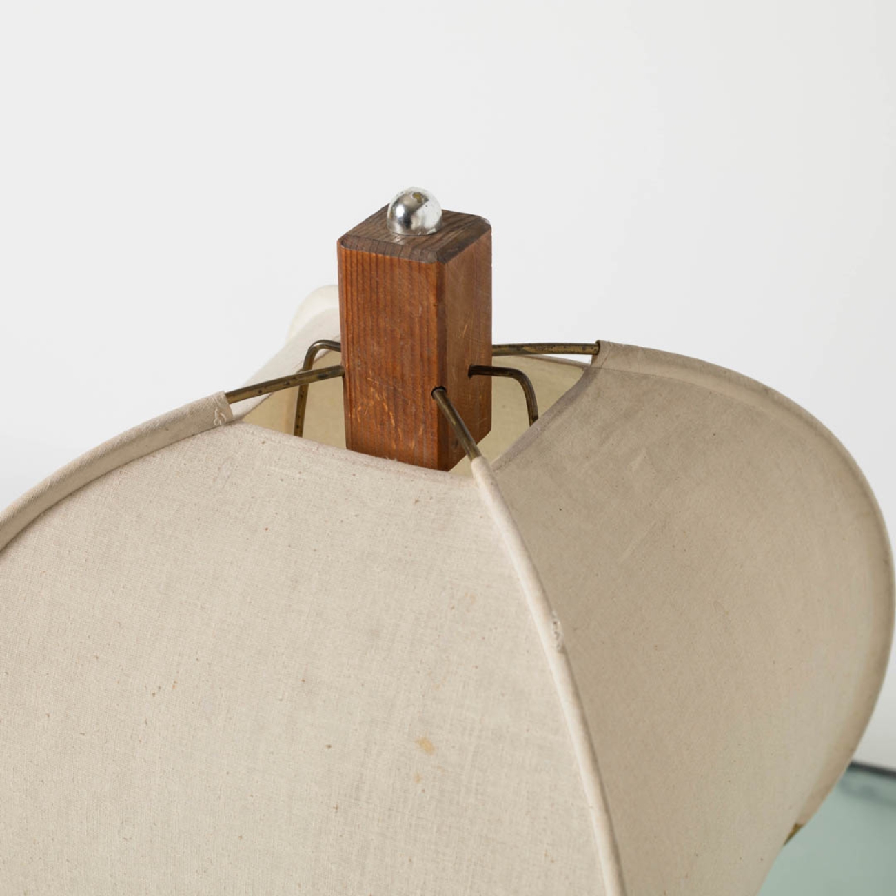 Close-up of the wooden base and fabric shade of the lamp.