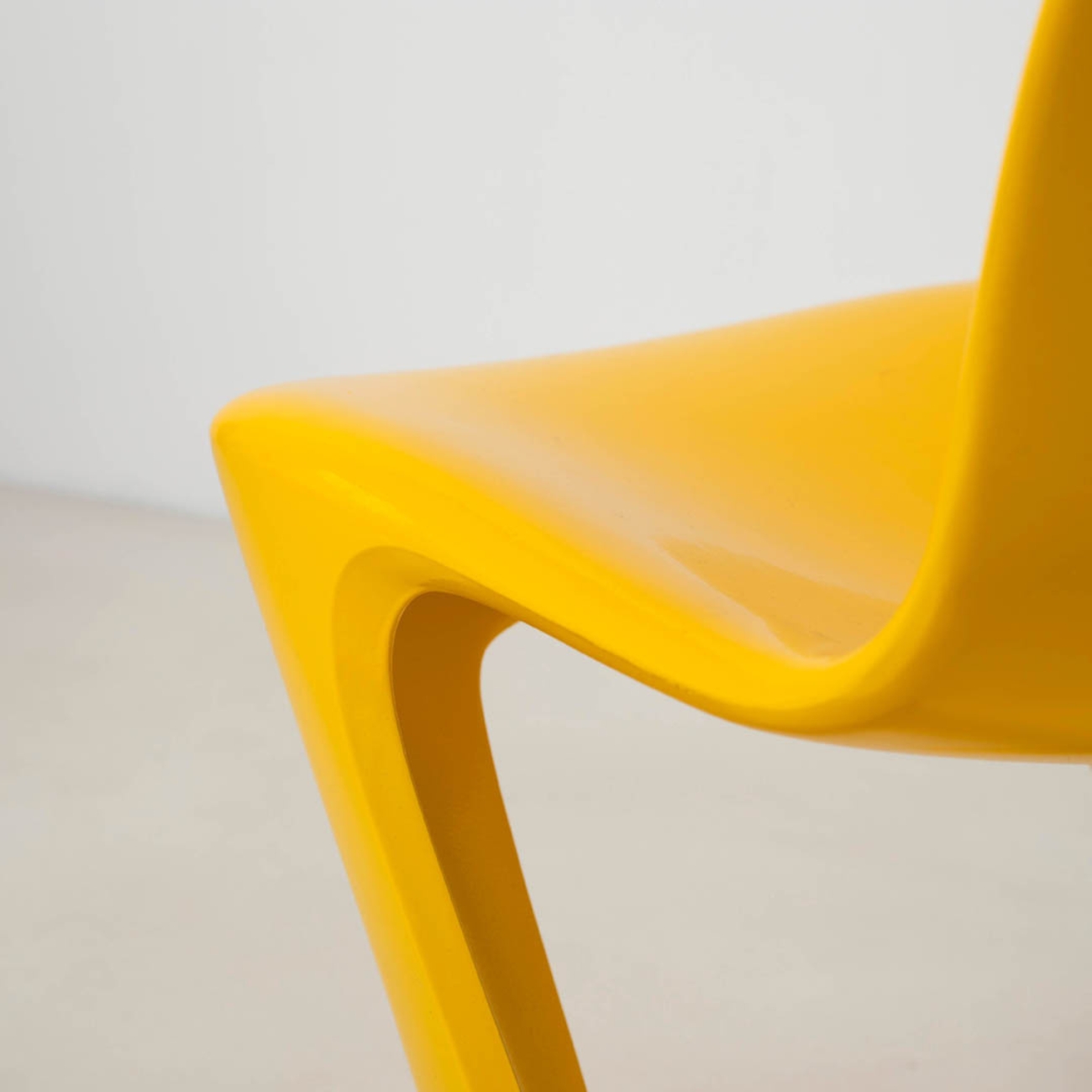 Close-up of the front seat edge and supporting leg of a Z-Stuhl chair showing its continuous molded form.