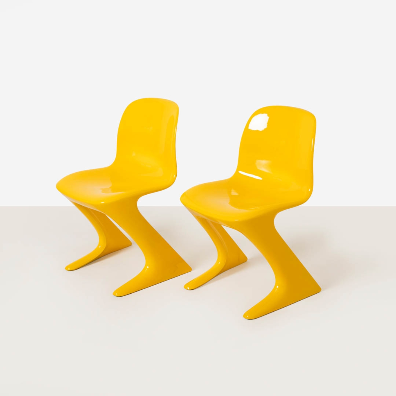 Pair of yellow Z-Stuhl chairs photographed from a three-quarter angle highlighting their sculptural form.