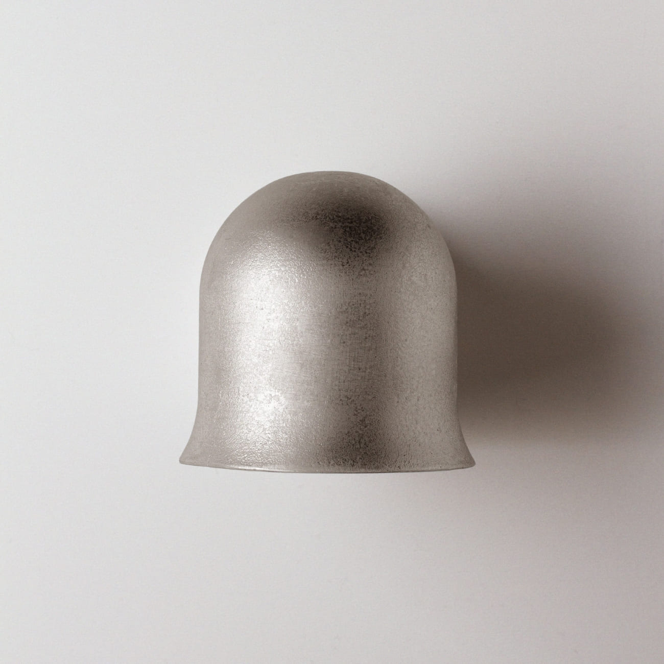 Zbliżenie powierzchni aluminiowego korpusu kinkietu Convallaria i jego zaokrąglonego profilu.