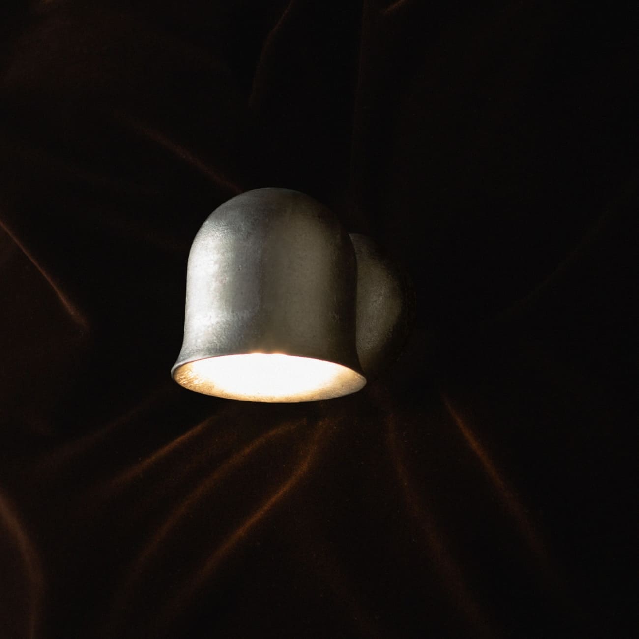 Zbliżenie powierzchni aluminiowego korpusu kinkietu Convallaria i jego zaokrąglonego profilu.