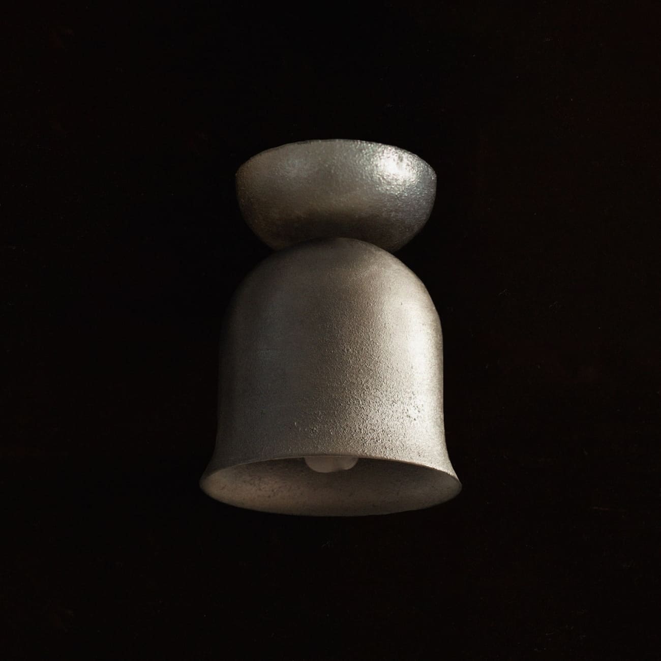 Convallaria z niepolerowanego aluminium, z widocznym dolnym otworem oprawy.
