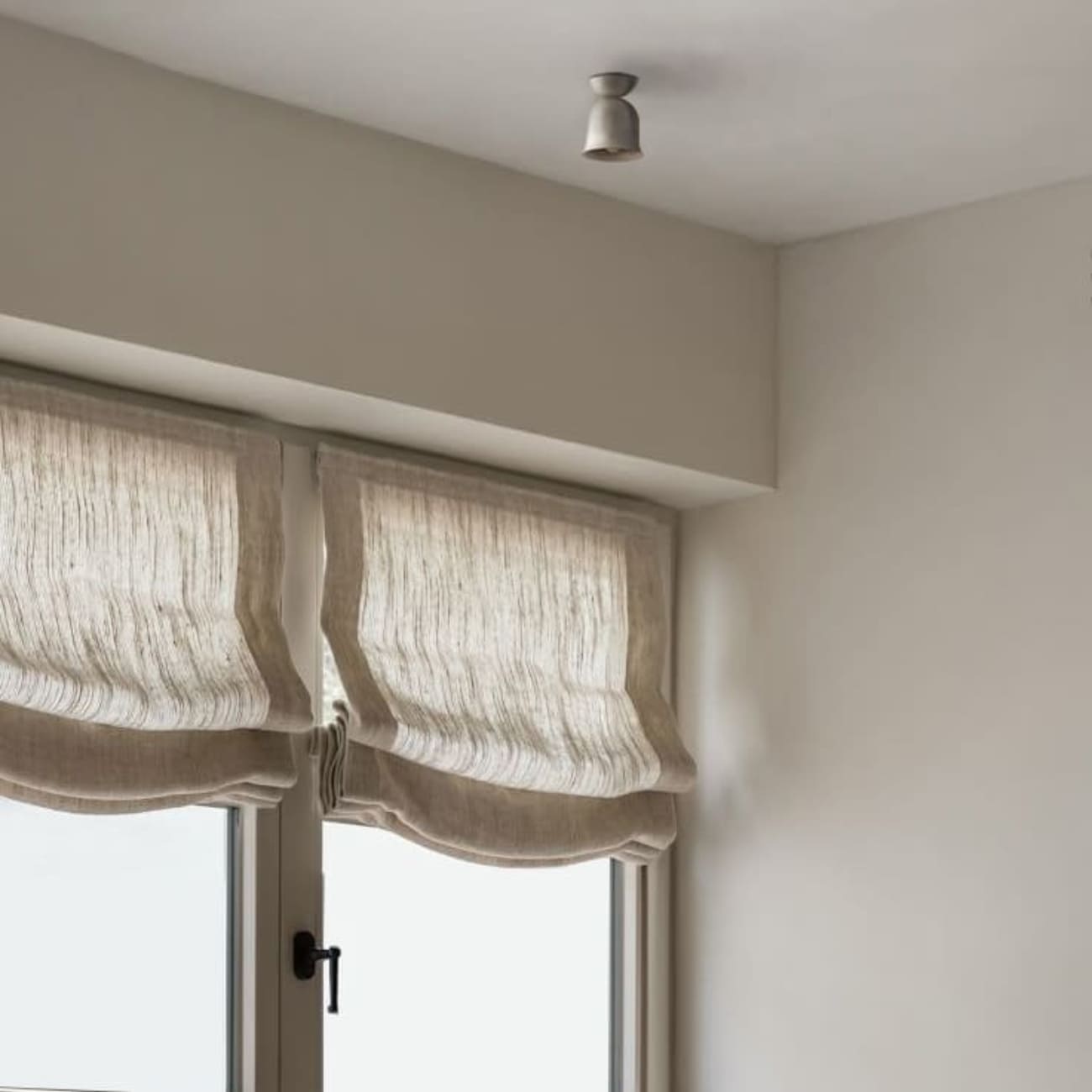 Lampa sufitowa Convallaria zamontowana przy suficie w jasnym wnętrzu nad kamiennym stołem.