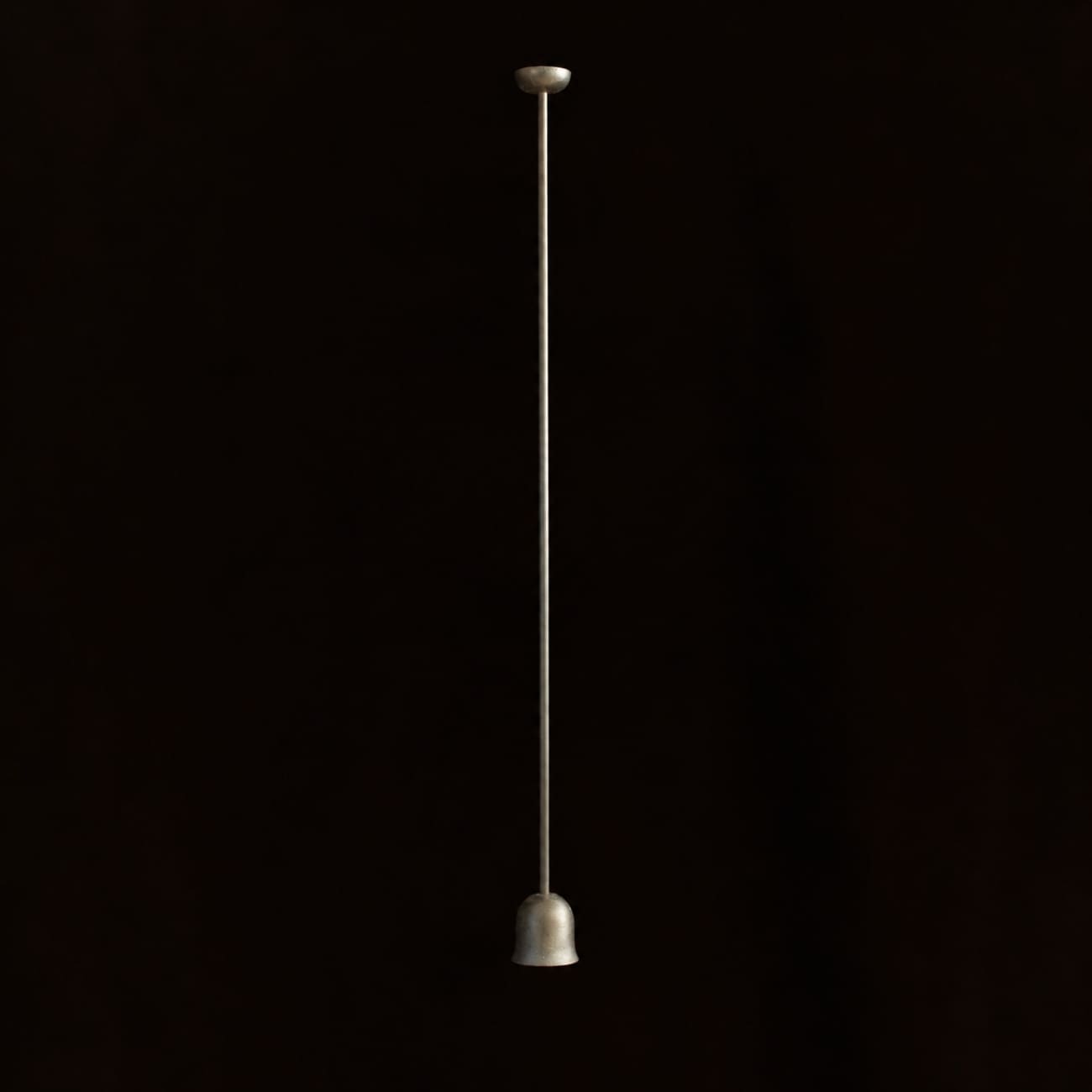 Lampa wisząca Convallaria z długim przewodem i niewielkim metalowym korpusem na czarnym tle.