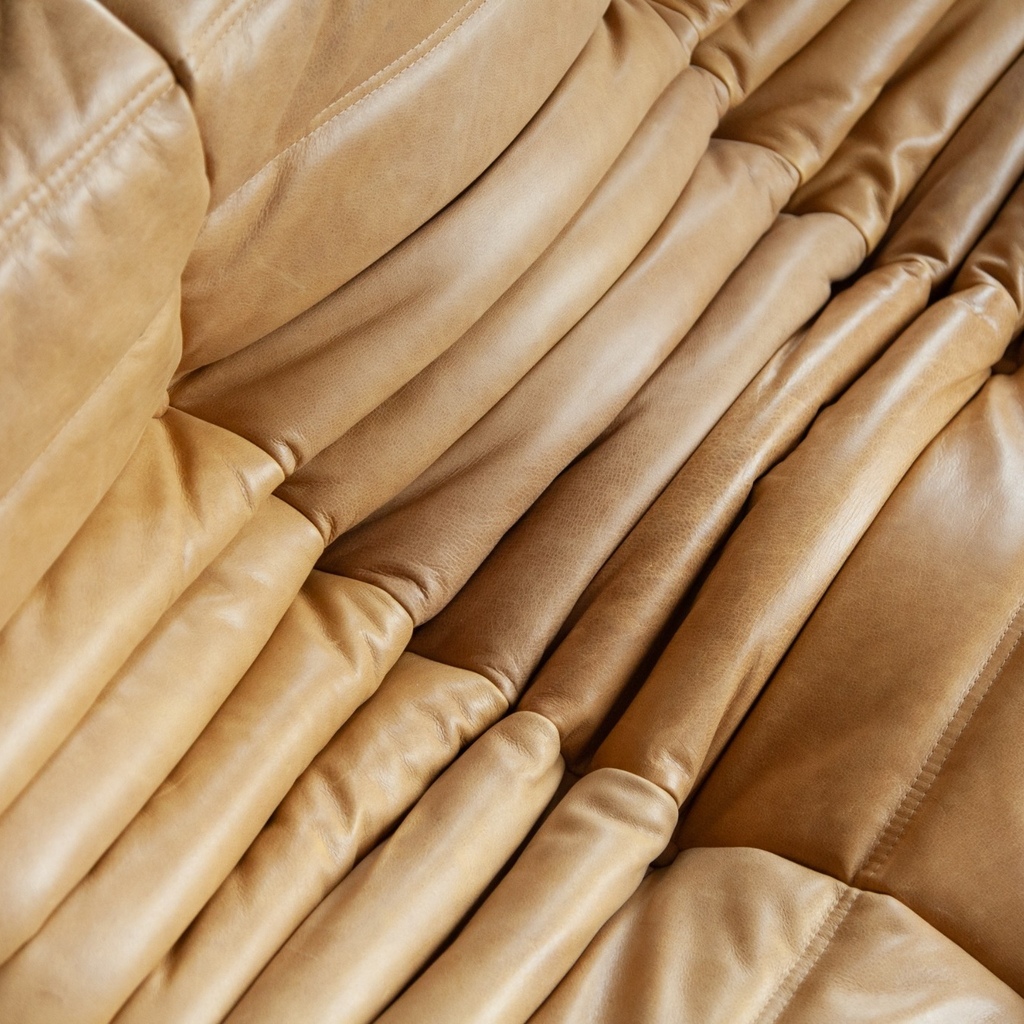 Pufa Togo vintage, zbliżenie tapicerki Brown Leather Camel z gęstymi fałdami, przeszyciami i widoczną fakturą jasnobrązowej skóry naturalnej.