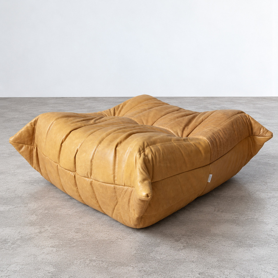 Pufa Togo vintage w jasnobrązowej skórze Brown Leather Camel, widok perspektywiczny na pikowane siedzisko, zaokrąglone narożniki i boczne marszczenia tapicerki.
