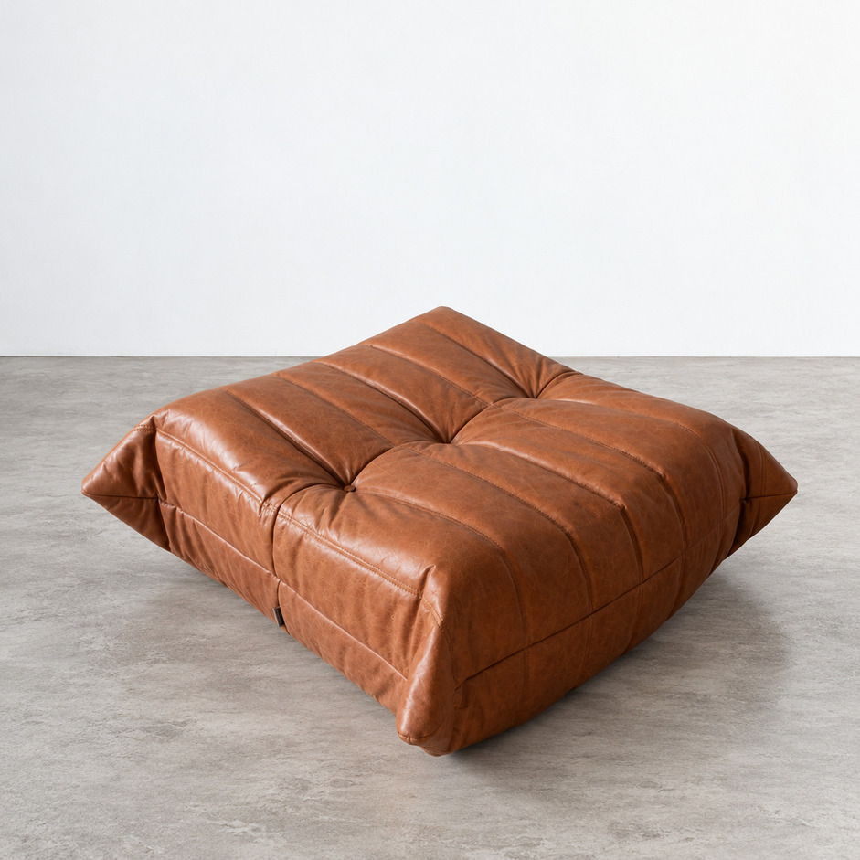 Pufa Togo vintage w brązowej skórze Brown Leather Peach, widok perspektywiczny na pikowane siedzisko, głębokie przeszycia i zaokrąglone krawędzie, proj. Michel Ducaroy, Ligne Roset.