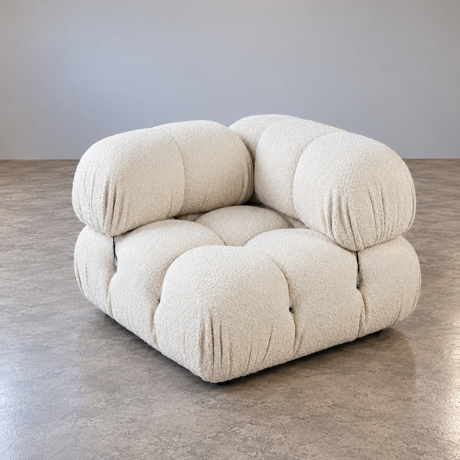 Fotel modułowy Camaleonda vintage w kremowej tkaninie bouclé, widok frontalny pod kątem na pikowane siedzisko i charakterystyczne zaokrąglone poduszki oparcia, proj. Mario Bellini, B&B Italia.
