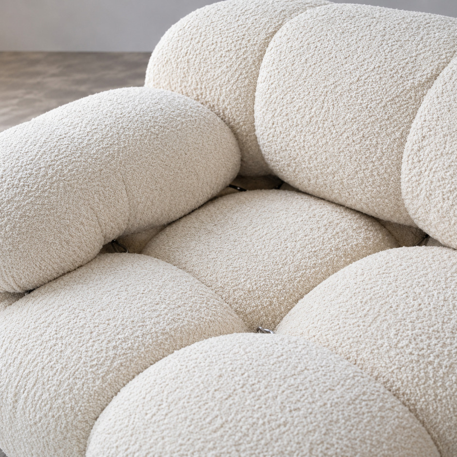 Sofa Camaleonda vintage, zbliżenie kremowej tapicerki bouclé, głębokiego pikowania siedziska i zaokrąglonych segmentów oparcia, proj. Mario Bellini, B&B Italia.